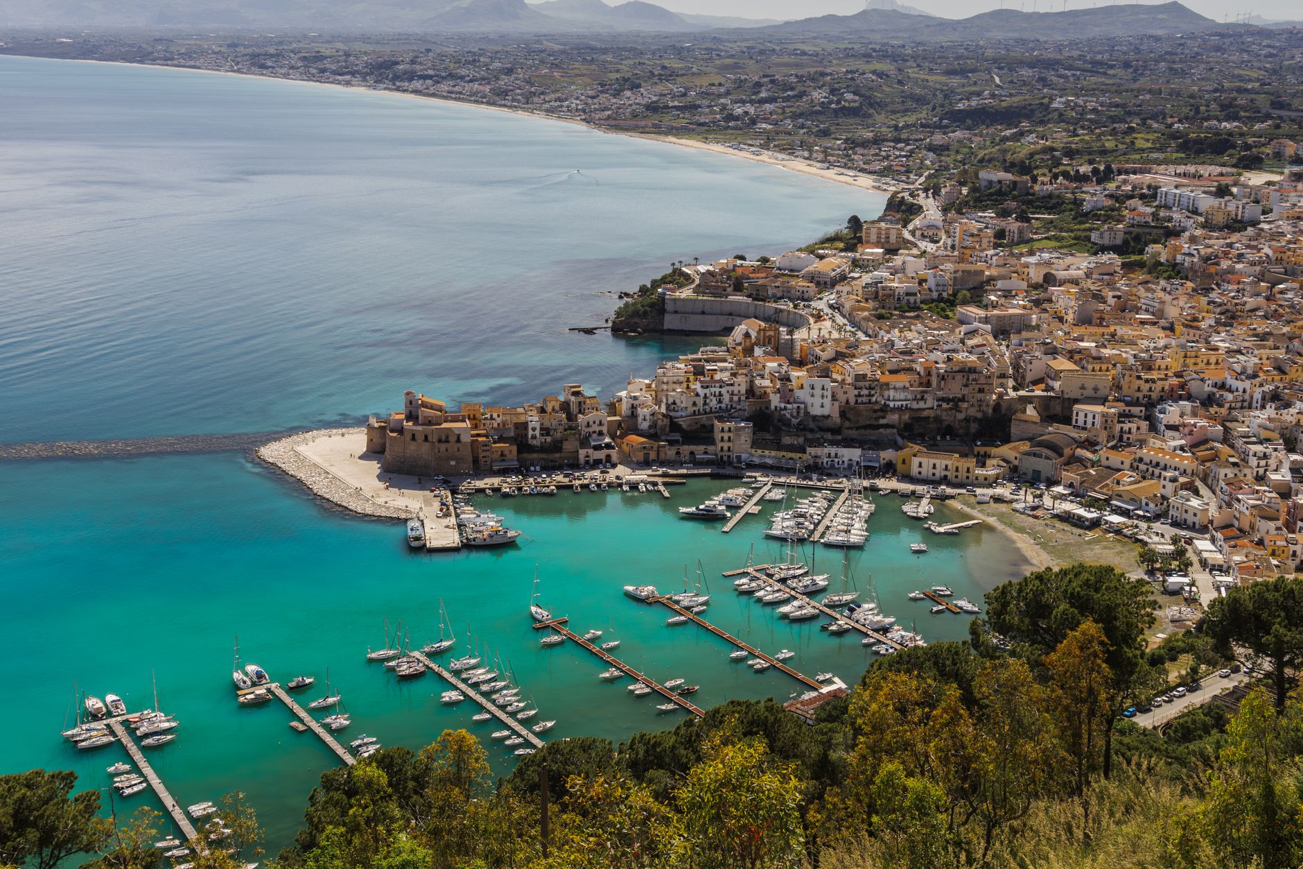 Breathtaking aerial shot of Castellammare del Golfo's vibrant harbor and coastline in Sicily, Italy.